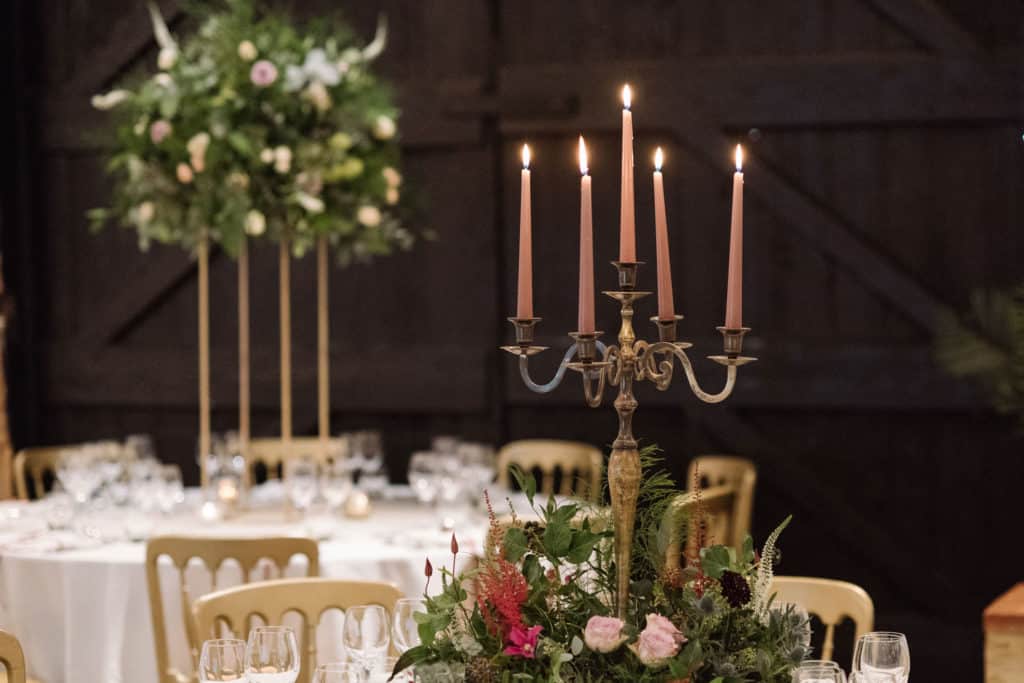 Flowers and candles set for wedding meal at South Farm Barn Wedding Venue
