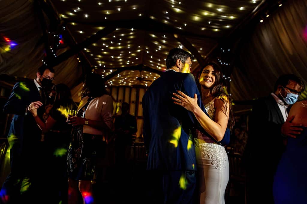Bride and groom have first dance at barn wedding venue under fairy lit canopy