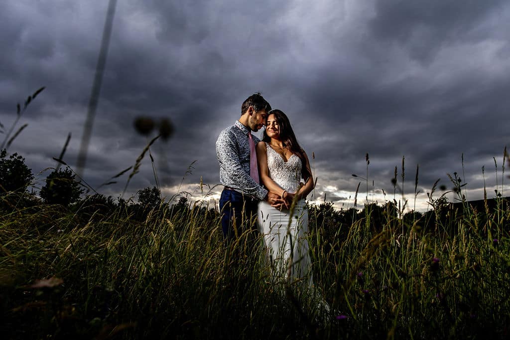 Bride and Groom with stormy skies at back drop on wedding day